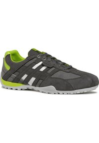 Scarpa sportiva in suede grigia con accenti bianchi e verde neon. Presenta un profilo basso, lacci a contrasto e una suola in gomma testurizzata.