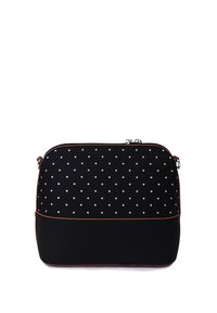 Black polka dot bag with a smooth texture and a solid black bottom. Features a zip closure and contrasting brown trim. Compact, rectangular shape.