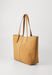 Borsa tote in suede beige con due manici, texture liscia, design minimalista, con una cucitura centrale e senza elementi hardware visibili.