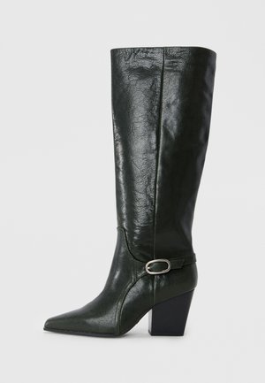Green leather knee-high boot with a pointed toe, block heel, and decorative strap with a silver buckle detail. Smooth texture with sheen.
