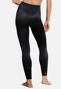 Leggings neri a vita alta realizzati in un tessuto elastico e lucido; presentano una leggera texture e un design aderente che si adatta al corpo.
