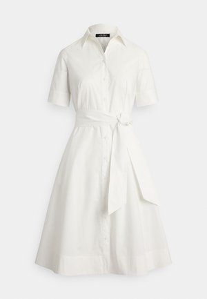 Bela srajčna obleka s kratkimi rokavi, z gumbi spredaj in pasom, ki poudarja pas s trakom za vezanje. Gladek bombažni material, A-linijski kroj.