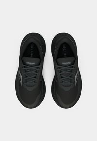 Mustad musta Saucony jooksejalatsite paar, siniste laiguliste taldade ja paeltega, nähtud ülalt valgel taustal.