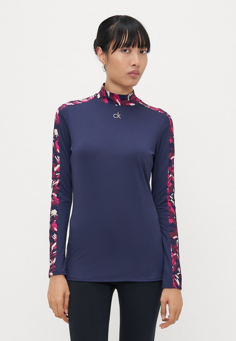 Navy Langarmoberteil mit hohem Kragen, floralen Akzenten an den Ärmeln und kleinem Logo auf der Brust, hergestellt aus glattem, dehnbarem Material.