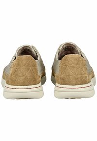 Braune Wildleder- und Strukturstoffschuhe zeigen ein dreieckiges Muster an der Ferse, mit einer weißen Sohle und dezentem Branding, das innen sichtbar ist.