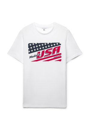Biała bawełniana koszulka z grafiką przedstawiającą flagę Stanów Zjednoczonych, napis "Made in USA", czerwoną i niebieską kolorystyką oraz casualowym krojem.