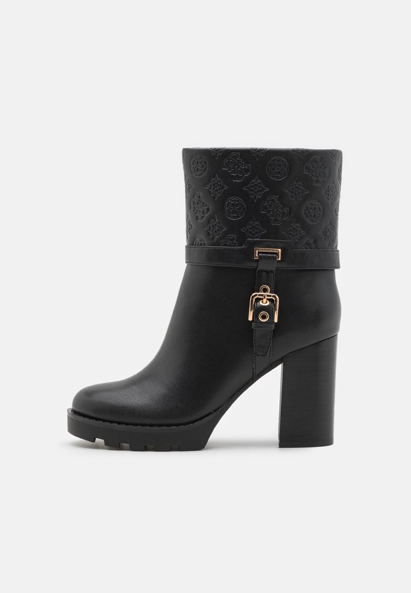 Bottine en cuir noir avec manchette à motif embossé, sangle à boucle dorée, talon bloc et semelle crantée, vue de côté sur fond blanc.