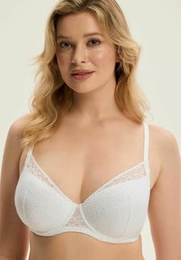 Biały koronkowy biustonosz o miękkiej fakturze, usztywnianych miseczkach, regulowanych ramiączkach oraz delikatnych koronkowych zdobieniach w górnej części.