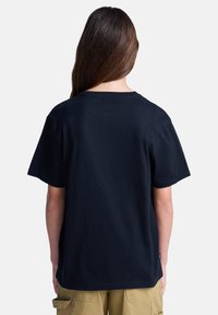 Μαύρο βαμβακερό μπλουζάκι με κοντά μανίκια και στρογγυλή λαιμόκοψη, με ίσια γραμμή και ελάχιστες λεπτομέρειες, που φαίνεται από πίσω.