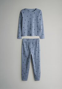 Lange mouwen lichtblauw pyjama set met zwarte sterpatronen. Top met ronde hals; broek met elastische tailleband en omgeslagen zoom.