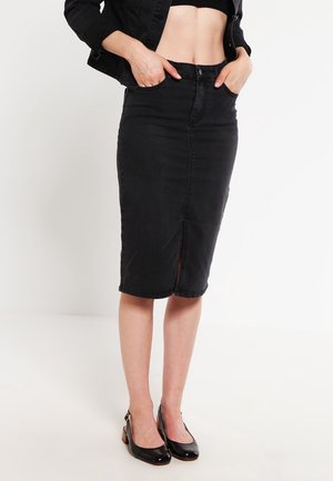 Schwarzer Jeans-Bleistiftrock mit Frontschlitz und hoher Taille. Verfügt über einen Knopfverschluss und zwei Fronttaschen. Kombiniert mit schwarzen Lackschuhen.