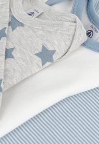 Tre T-shirts staplade: grå med blå stjärnor, vit och ljusblå randig tyg. Mjuk bomull med ribbad halsringning.