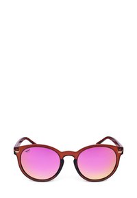 Kulaté sluneční brýle s průhledným červeným rámečkem a gradientovými růžovými skly, s jemným detailem loga v levém horním rohu rámečku.