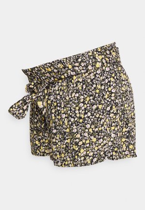 Pantalones cortos florales con un fondo negro y flores amarillas y moradas, cinturilla elástica y detalle de lazada lateral. Tejido ligero.