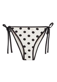 Witte bikinibroekje met zwarte polka dots, zwarte rand en verstelbare zijstrikjes op een witte achtergrond.