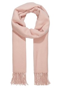 Écharpe en tricot rose pâle et douce avec des extrémités à franges, pliée en boucle lâche sur un fond blanc.