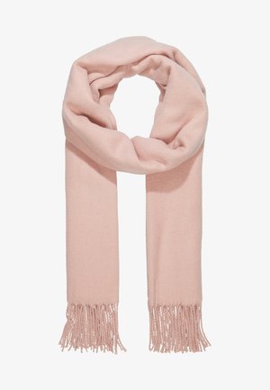 Écharpe en tricot rose pâle et douce avec des extrémités à franges, pliée en boucle lâche sur un fond blanc.