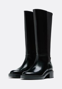 Črni škornji do kolen iz usnja z sijočim zaključkom, s kontrastnim mat panelom iz tkanine, kvadratnim prstom in blok peto.