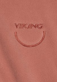 Fleece-stoff i støvete rosafarge med brodert tekst "VIKING" over et buet smiledesign. Glatt tekstur, ingen synlige mønstre.