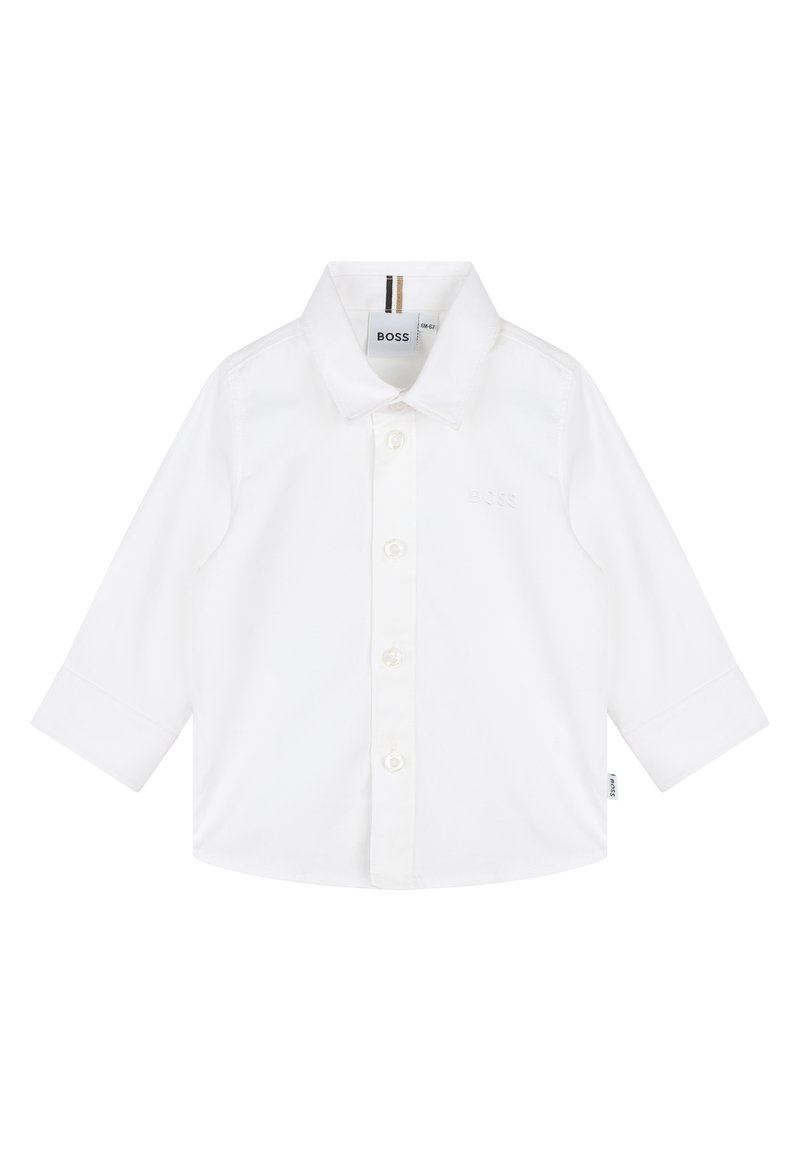 Camisa branca de manga comprida feita de algodão, com frente de botões, gola pontiaguda e uma marcação subtil no peito.