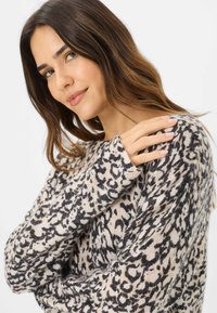 Leopardmønstret sweater i blød beige og sort strik. Har en afslappet pasform, lange ærmer og ribbede manchetter.