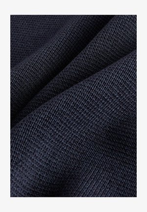 Tumši zili teksturēts audums ar ribotu rakstu, kam ir mīksta, austo izskats. Daudzās krokās rodas slāņveida efekts.