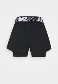 Pantalones cortos deportivos negros con una cinturilla elástica blanca en contraste que presenta el logotipo de "New Balance", diseño en capas con pantalones cortos de compresión internos.