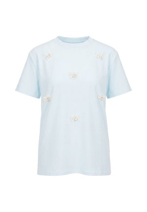 Lys blå kortærmet t-shirt med seks små hvide stofblomsterapplikationer jævnt fordelt på forsiden.