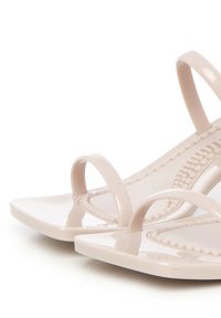 Lichtroze sandalen met een glanzende afwerking, voorzien van twee dunne bandjes en een gestructureerde voetbed met parelachtige accenten. Vierkante neusvorm.