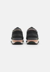 Schwarze Saucony-Sneaker verfügen über ein Obermaterial aus Mesh, Wildlederakzente und eine gepolsterte Sohle. Helle rosafarbene Details an der Ferse und der Sohle sorgen für einen Kontrast.
