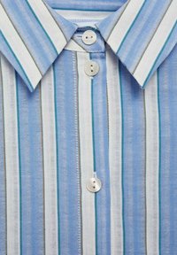 Chemise à manches courtes avec boutons, rayures verticales bleues et blanches, col classique et trois boutons. Tissu texturé.