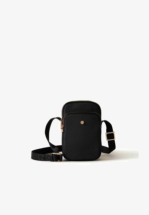 Borsa a tracolla nera testurizzata con tracolla regolabile, cerniera dorata e piccolo emblema rotondo sulla tasca frontale.