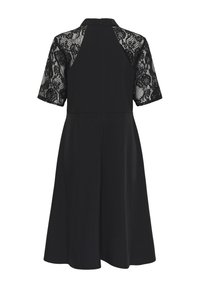 Robe noire mi-longue aux genoux avec manches courtes en dentelle florale et col montant vue de dos.