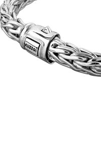 Silverfärgad flätad armband med ett spänne i fyrkantig design och ingraverad logotyp. Detaljer inkluderar en polerad yta och intrikat flätning.
