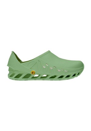 Chaussure verte à enfiler avec semelle ventilée et perforations latérales, conçue pour le confort et la respirabilité.