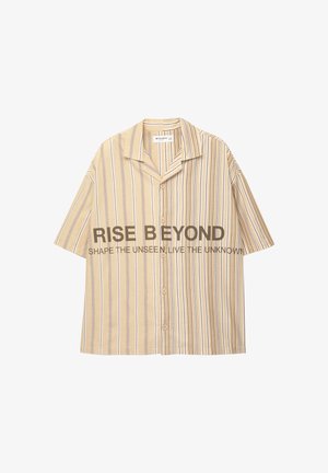 Camicia a maniche corte, con bottoni, di colore beige chiaro con strisce verticali marroni e blu. Presenta un colletto a punte e una grafica testuale sul davanti.