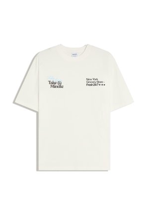 Fehér rövid ujjú póló fekete felirattal: "Take a Minute" a bal mellrészen, és "New York Grocery Store - Fresh 24/7" a jobb mellrészen.