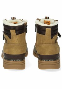 Bottines en suède marron avec doublure en fausse fourrure, dotées d'une semelle robuste, d'un textile matelassé sur le haut et de zips latéraux pour un enfilage facile.