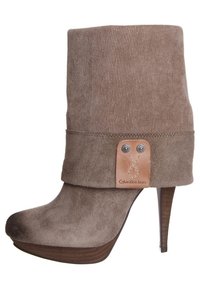 Brązowe zamszowe botki za kostkę z wywiniętym fasonem, fakturowaną powierzchnią, wysokim obcasem oraz skórzaną metką z nazwą marki w skórzanych akcentach.