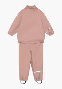 Vattentät rosa tvådelad outfit med jacka som stängs med dragkedja och elastiska manschetter. Har reflekterande detaljer på ärmarna och byxorna.