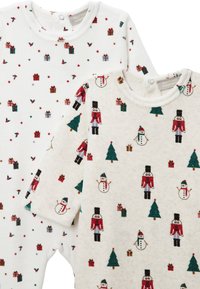 Deux bodys bébé à manches longues. L'un blanc avec des imprimés cadeaux colorés, l'autre crème avec des motifs de casse-noisette, bonhomme de neige et arbre. Tissu doux.