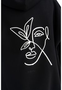 Felpa nera con ricamo bianco di un volto e foglie; design semplice e minimalista con un contrasto e una texture notevoli.