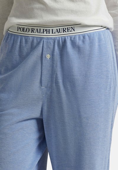 Světle modré pyžamové kalhoty vyrobené z měkké tkaniny, s knoflíkovým zapínáním a elastickým pasem s černým logem "POLO RALPH LAUREN".