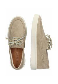 Chaussures en daim beige avec un bout rond, semelle en caoutchouc blanche et lacets gris clair. Présente des accents cousus et le logo "BLACKSTONE" sur la semelle intérieure.