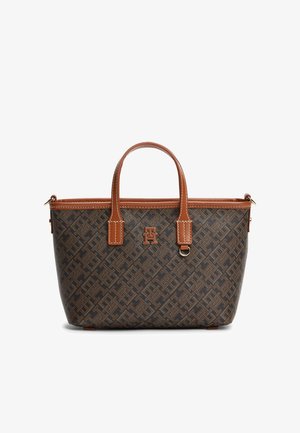 Braune Handtasche mit Muster, hellbraunen Ledergriffen, genähtem Rand und metallischem Logo auf der Vorderseite, vor weißem Hintergrund gezeigt.