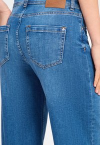 Lichtblauwe denim jeans met een klassieke vijf-pocket ontwerp, rechte pijpen en een gestructureerde leren patch op de tailleband.