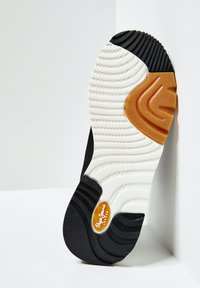 Suola della scarpa con motivi di battistrada bianchi, neri e marroni, con il logo di Pepe Jeans London vicino al tallone.