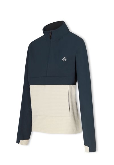 Kvartsdraget tröja i marinblått och krämfärgat, med ett texturerat rutmönster på den nedre halvan, samt en ståkrage och logotypdetalj.