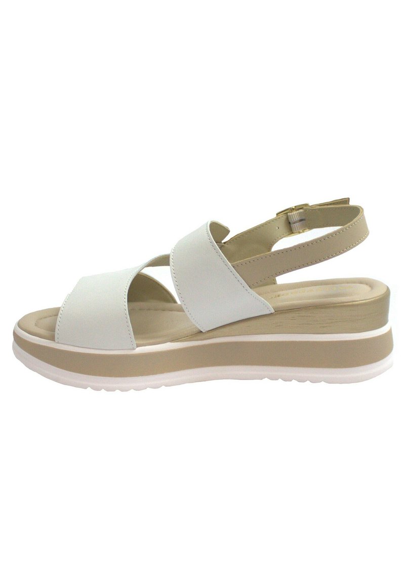 Sandalo platform bianco con cinghie incrociate, cinturino regolabile alla caviglia e suola chunky beige. Texture liscia con dettagli minimi.