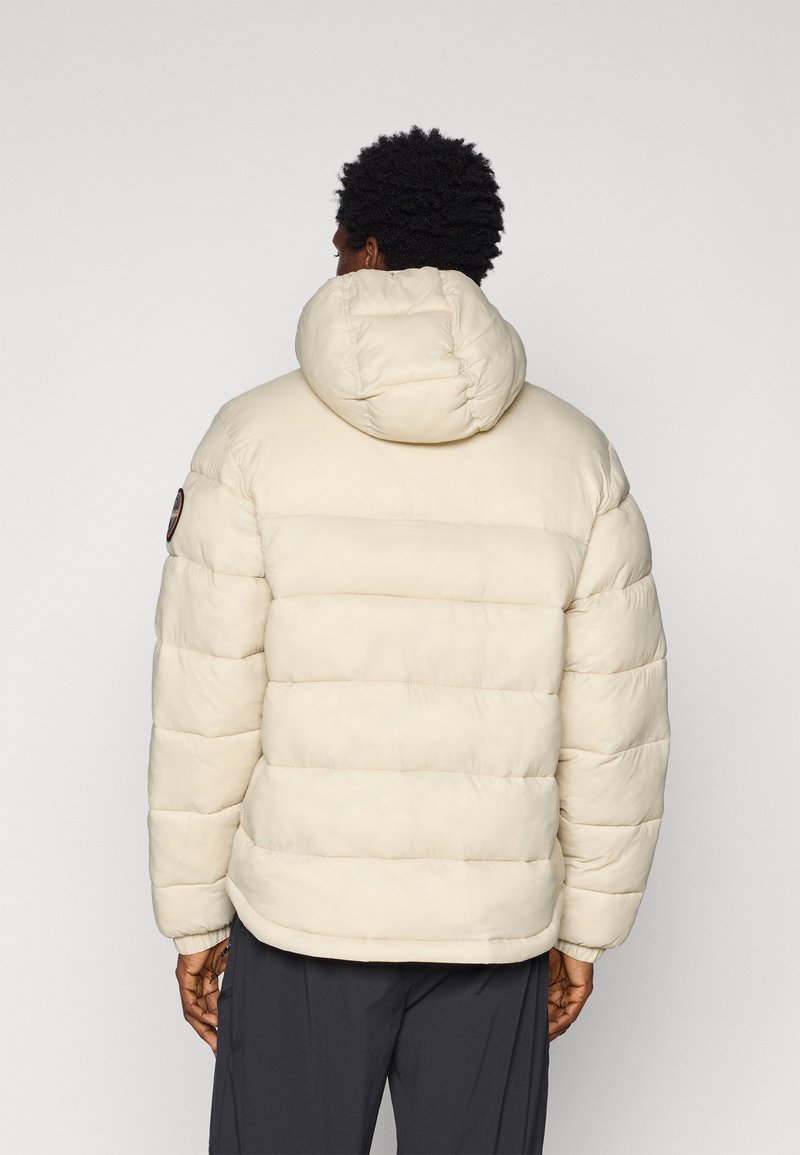 Jasno beżowa kurtka puchowa z kapturem, z poziomymi przeszyciami i elastycznymi mankietami. Naszywka z logo na lewym ramieniu.